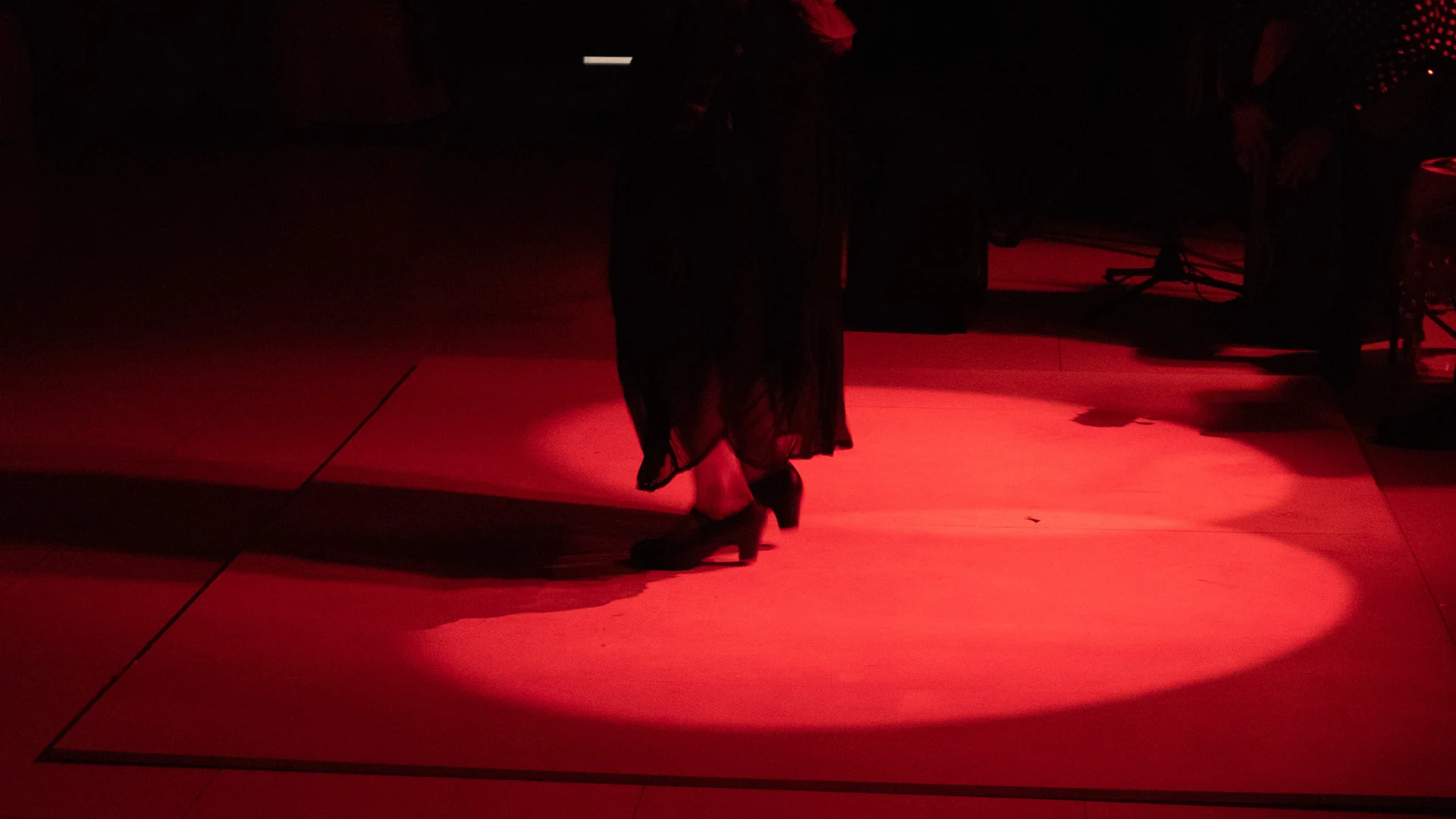 Un foco rojo ilumina el escenario a oscuras